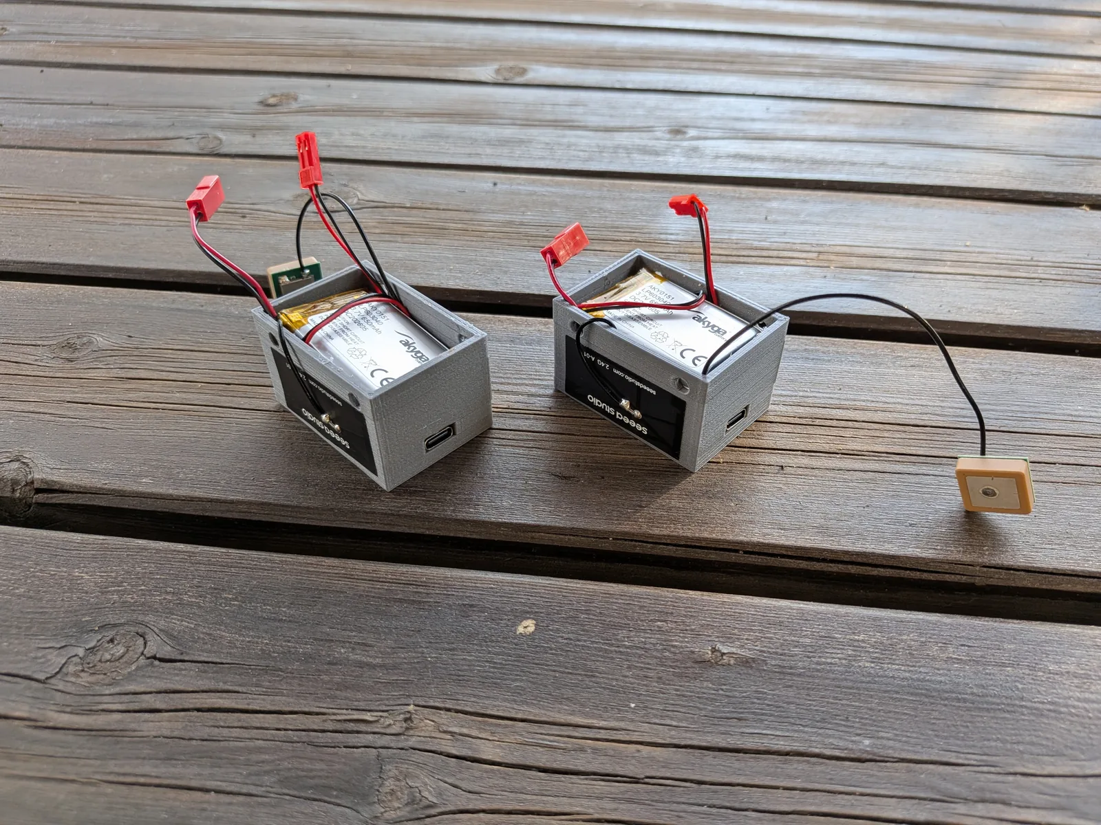 Two assembled CatTracker GPS units in custom 3D-printed enclosures